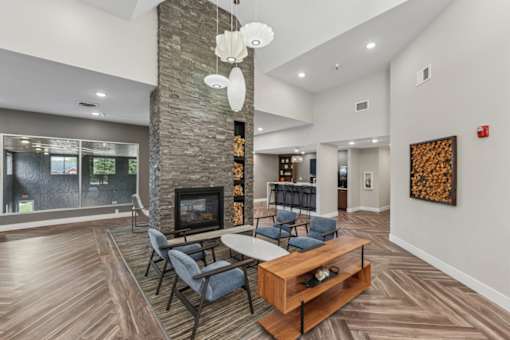 A modern living room with a stone fireplace and a wooden coffee table.