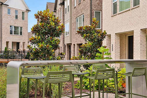 A row of green chairs are lined up on a concrete bench.