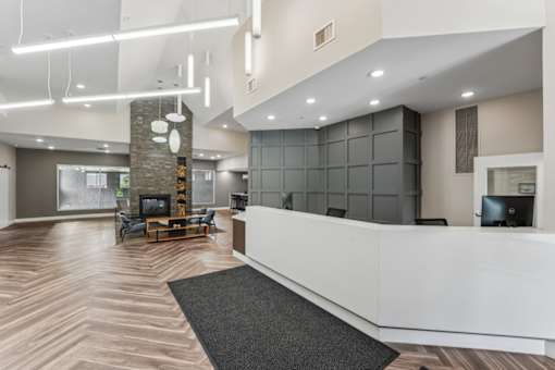 A reception area with a white counter and a grey rug.