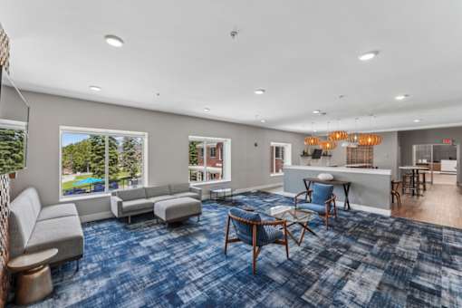 A spacious living room with a blue carpet and furniture.