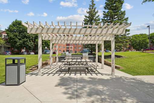 A white pergola is over a picnic table.