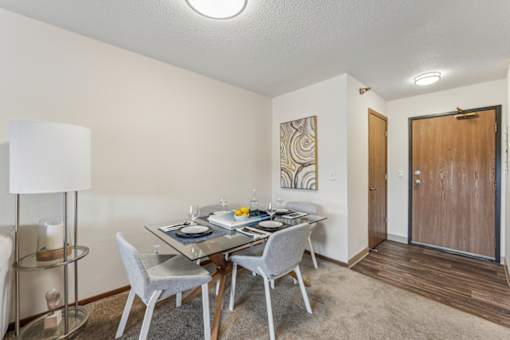 A dining room with a glass table and chairs.
