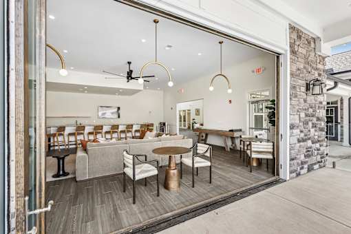 A modern dining area with a glass wall separating it from the rest of the room.