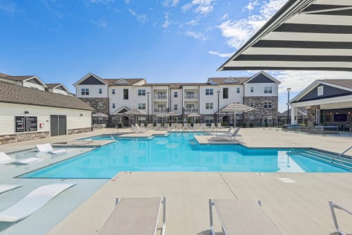 our apartments have a large swimming pool with chairs and umbrellas