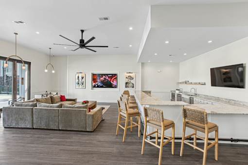A modern living room with a grey couch and wooden chairs.