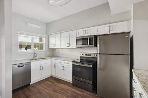 A kitchen with white cabinets and stainless steel appliances.