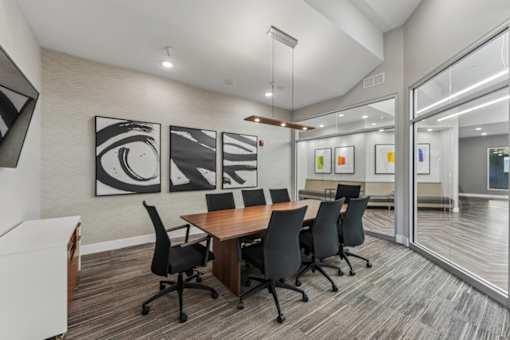 A conference room with a long table and chairs.