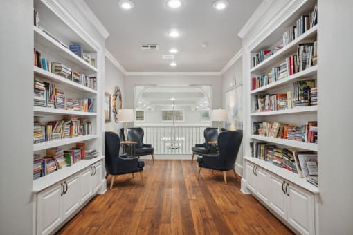 a living room filled with bookshelves and chairs