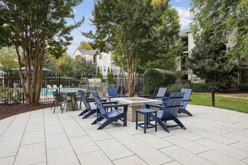 an outdoor patio with blue chairs and tables and a pool