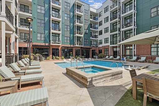 A large outdoor pool area with sun loungers and a wooden deck.