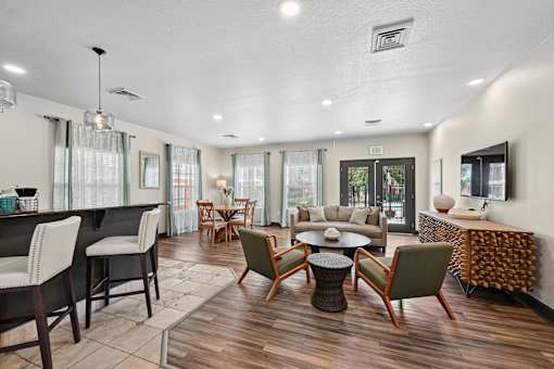 A well-lit, modern living room with a variety of seating options and a dining table.