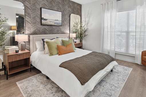 A bedroom with a large bed and a painting on the wall.