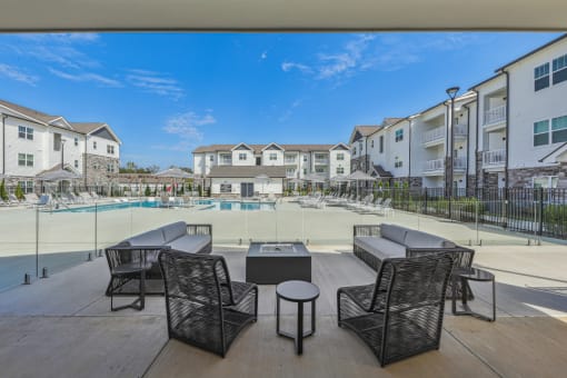 an outdoor patio with tables and chairs next to a pool