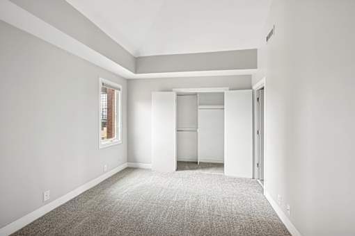 A large, empty room with a carpeted floor and white walls.
