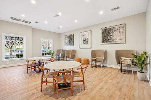 A room with wooden floors and furniture, and three pictures on the wall.