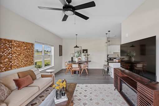 A living room with a couch, a coffee table, and a ceiling fan.