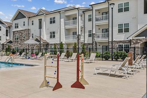 A poolside with chairs and a climbing wall.