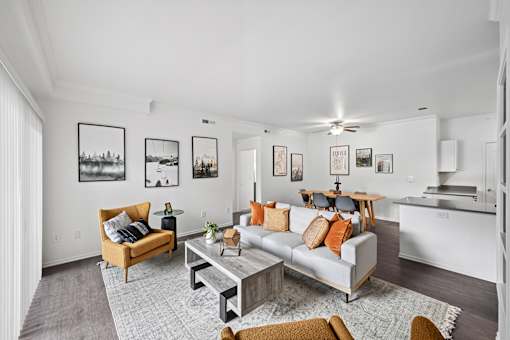A living room with a grey couch, a coffee table, and a ceiling fan.
