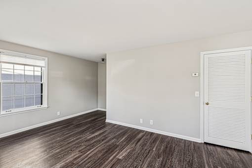 A room with a white door and a window with blinds.