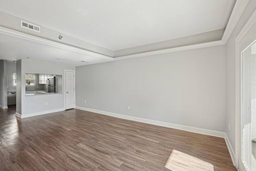 A room with wooden flooring and white walls.