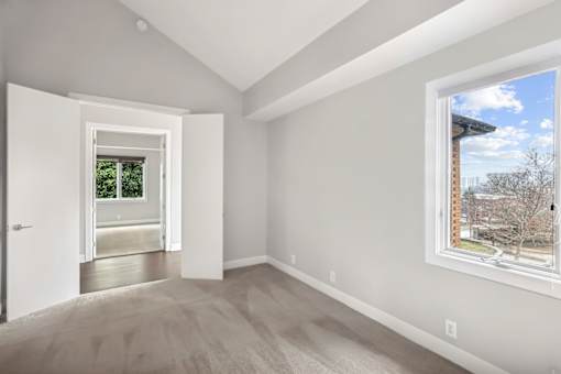 A room with a window and a door leading to another room.