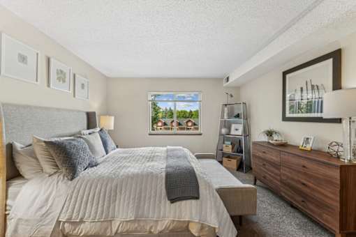 A bedroom with a large bed and a dresser.