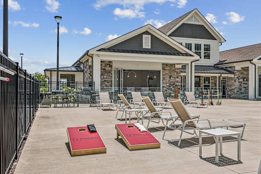 A patio with chairs and a table in front of a house.