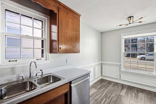 A kitchen with a window overlooking a parking lot.