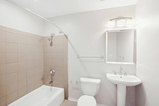 A white bathroom with a tub, toilet, and sink.