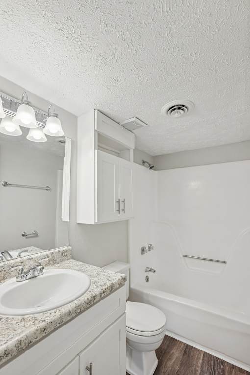 A white bathroom with a sink, toilet, and bathtub.