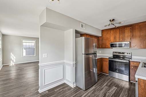 A kitchen with a refrigerator, oven, and microwave.