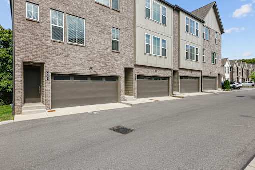 A row of houses with garages on the side.