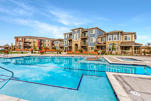 A large swimming pool in front of apartment buildings.
