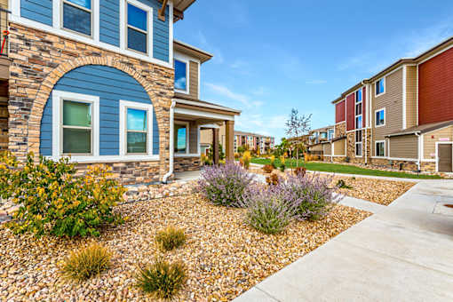 A blue house with a gravel garden in front.