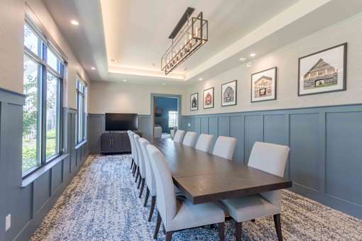 A long table with chairs is set up in a room with a blue wall.