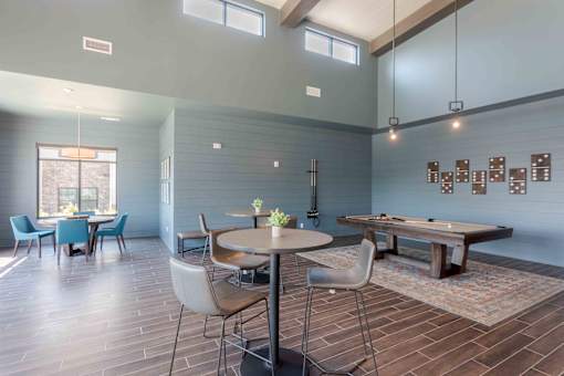 A room with a pool table and a dining table.