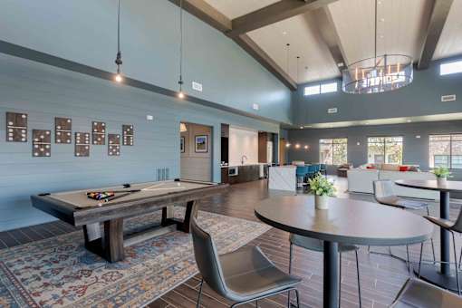 A room with a pool table and a billiard table.