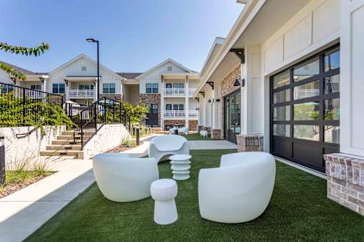 A white outdoor furniture set is placed on a green lawn.