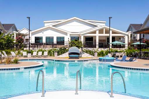 A large white house with a pool in front.