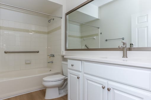 A white bathroom with a toilet, sink, and bathtub.