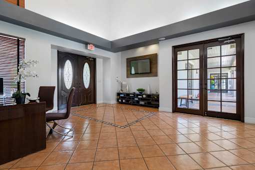 A room with a brown tile floor and a brown chair.