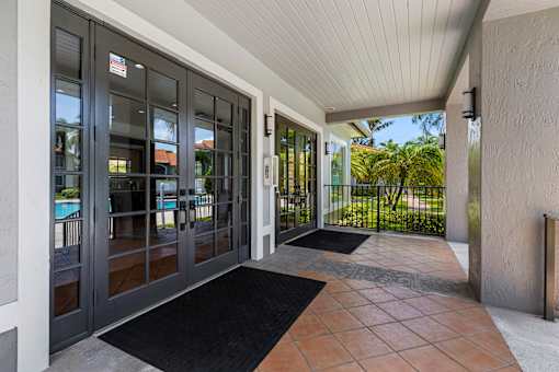 A glass door with a black mat in front of it.