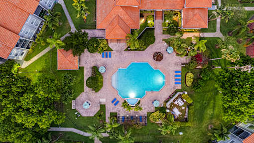 A swimming pool surrounded by a grassy area and trees.