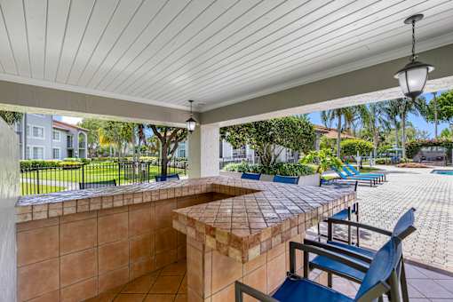 A patio with a table and chairs under a roof.