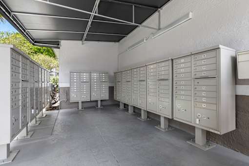 A row of metal filing cabinets are lined up in a room.