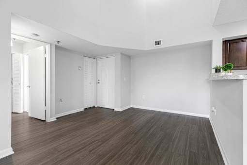 A room with wooden flooring and white walls.