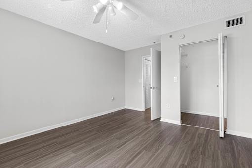 A room with a ceiling fan and a sliding door.
