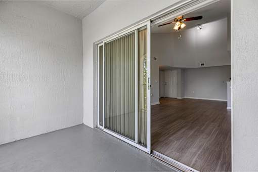 A room with a sliding door and a fan on the ceiling.