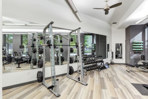 a gym with gym equipment and weights on a wooden floor