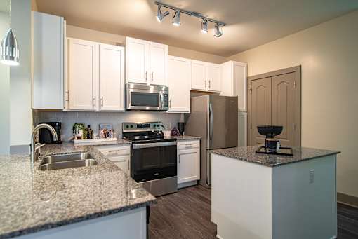 A kitchen with granite countertops and stainless steel appliances.